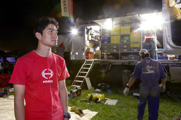 Hiroyuki Sugiura looks on as mechanics service the truck.