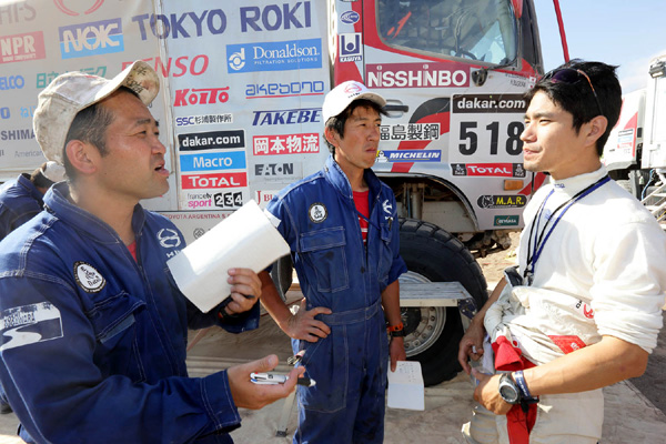 Hiroyuki Sugiura explains his truck's condition to mechanics.