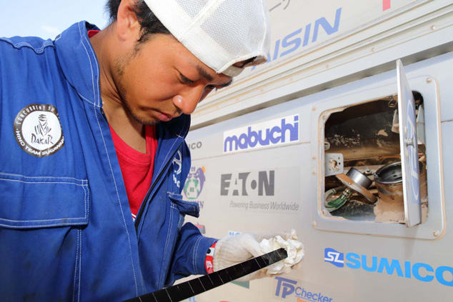 Mechanic Hiroya Fukuno checks the remaining fuel using an inspection scale.