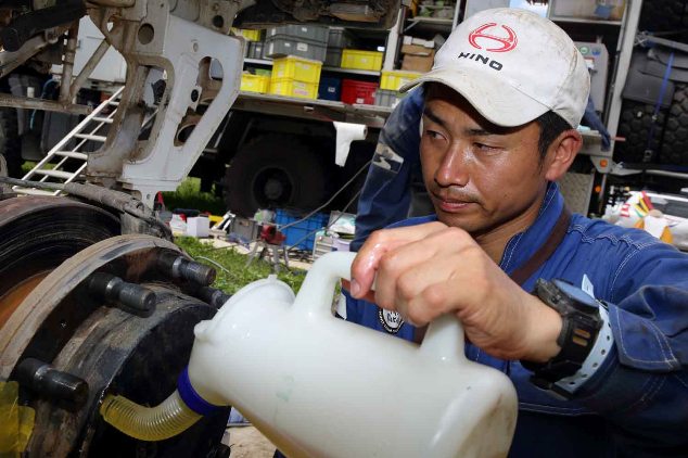 Mechanic, Hideyuki Sakaguchi oils the reduction hub on Car 2.