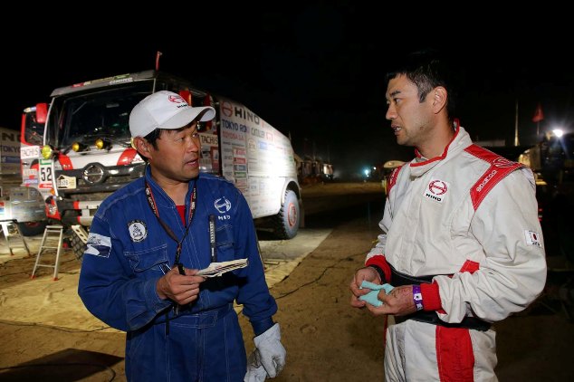 Mitsugu Takahashi instructs a mechanic on how much to refuel.