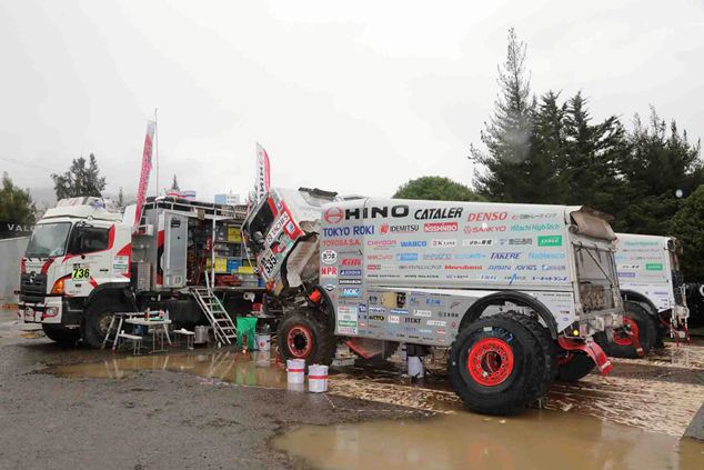 The team services their HINO500 Series trucks under bad weather.