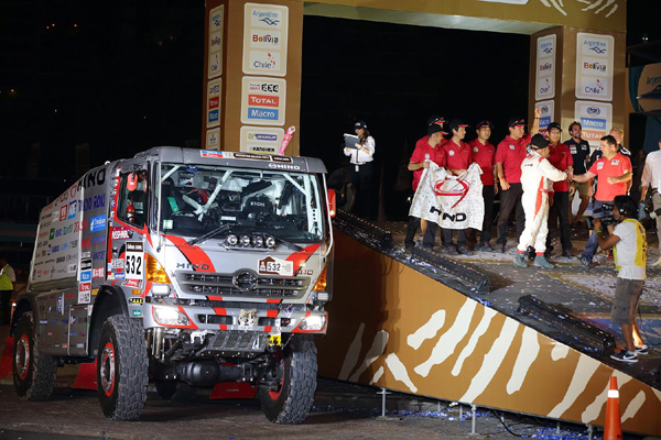 Yoshimasa Sugawara shakes hands with an organizer staff member on the podium.