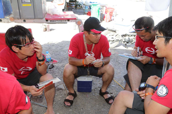 Mechanics go over servicing procedures before the HINO500 Series racing trucks arrive.