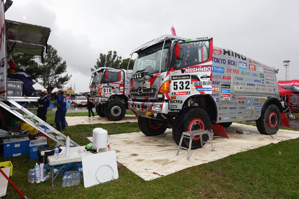 Mechanics service the HINO500 Series trucks in the drizzle.