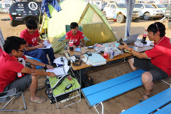 Team members take care of administrative work while they wait for their rally trucks.