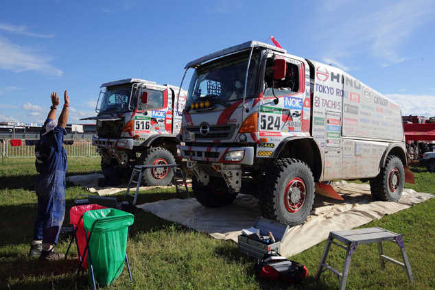 A mechanic signals to Car 1 as it arrives at the bivouac.