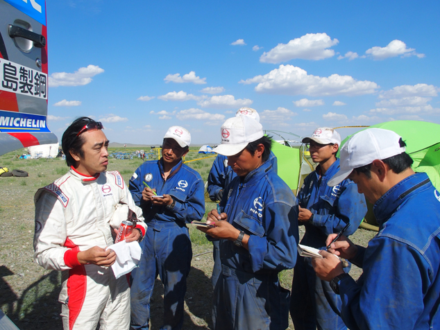 Teruhito Sugawara and mechanics go over settings.