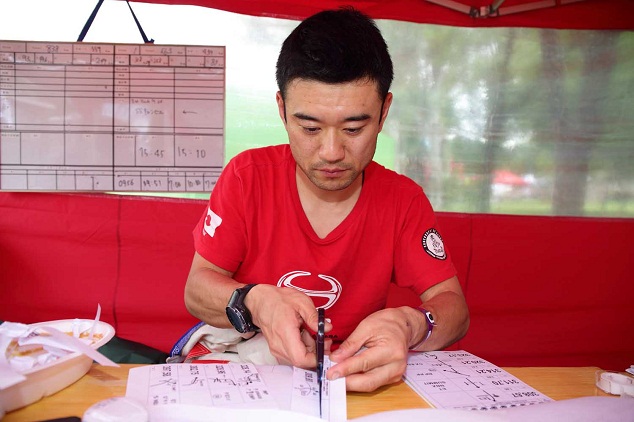 Mitsugu Takahashi (navigator) cuts and pastes his road book to reflect the changes that were made.