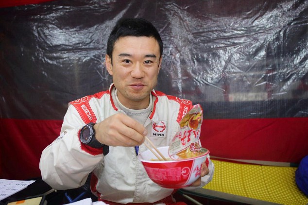 Mitsugu Takahashi enjoys a bowl of ramen in the team's tent.