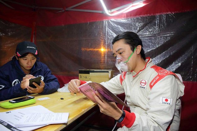 Teruhito Sugawara checks the roadmap for the following day with his oxygen mask on.