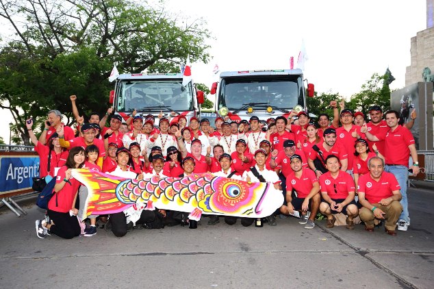 A group photo of Hino team members, and staff and associates of Hino Argentina by the goal podium.