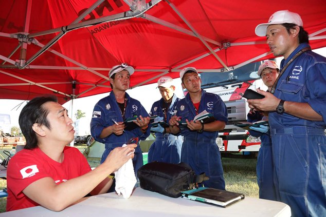 Teruhito Sugawara discusses servicing details with mechanics.