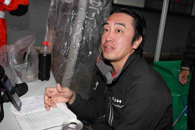 Teruhito Sugawara is confirming servicing details with mechanics.