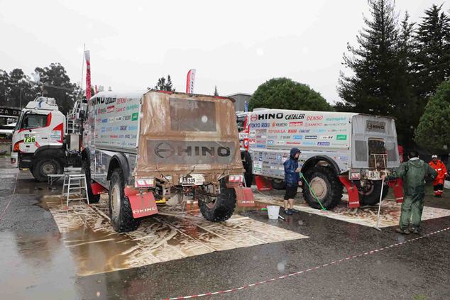 Team members wash the HINO500 Series trucks in the rain.
