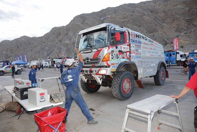 Mechanics guide Car 2 to its parking spot after it arrives at the bivouac.