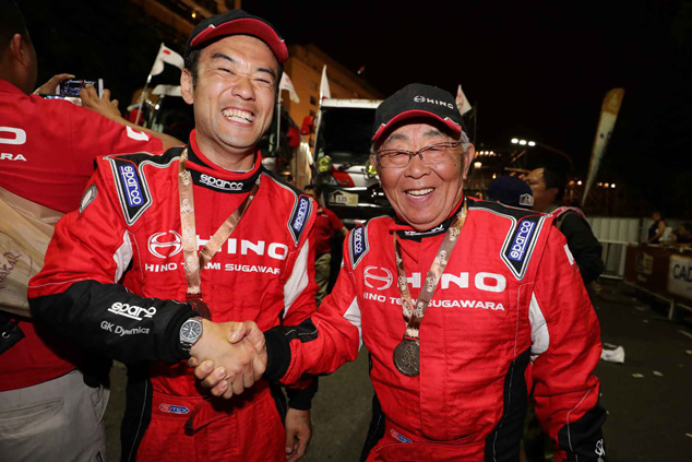 Yoshimasa Sugawara shakes hands with his Car 1 crew mate, Mitsugu Takahashi.